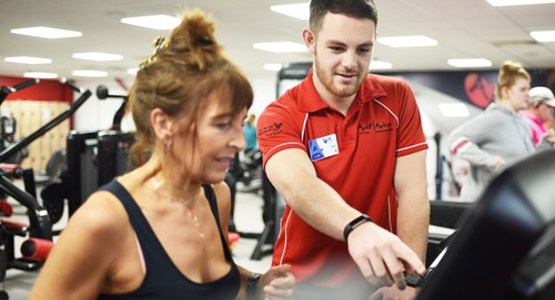 Woman having an induction on the treadmill from an actif team member