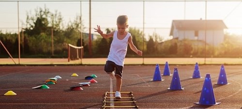 Child running over a speed ladder